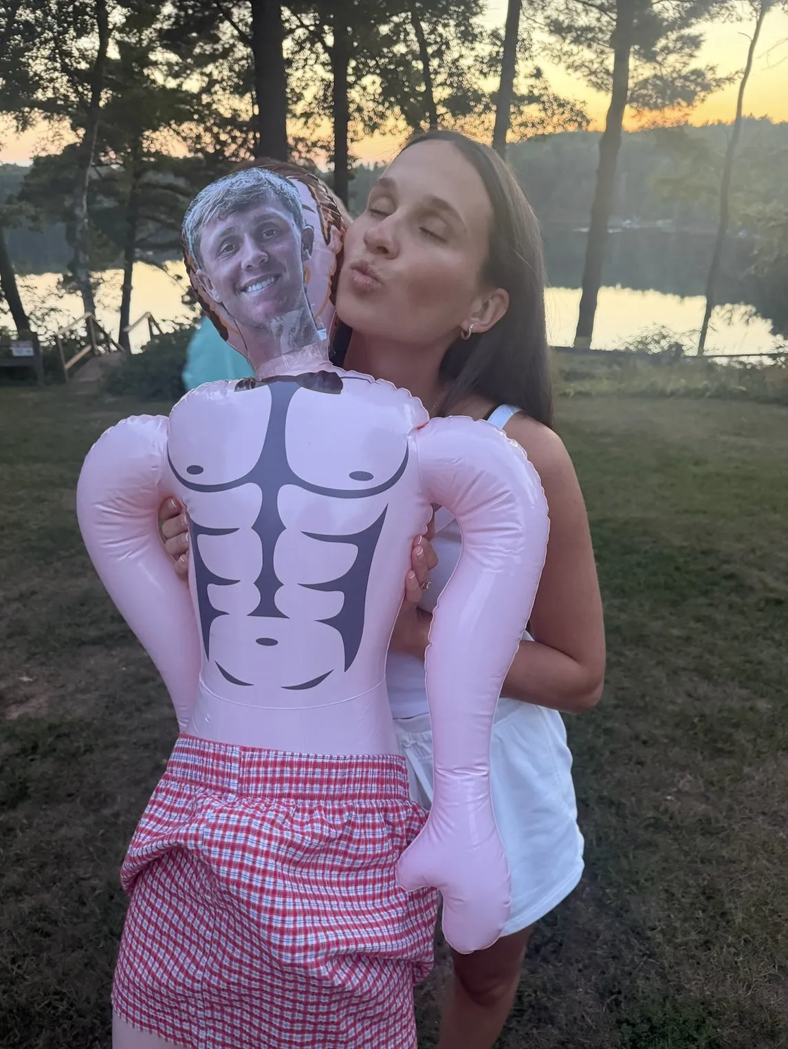 The bride with a blow-up doll wearing the groom’s face at sunset